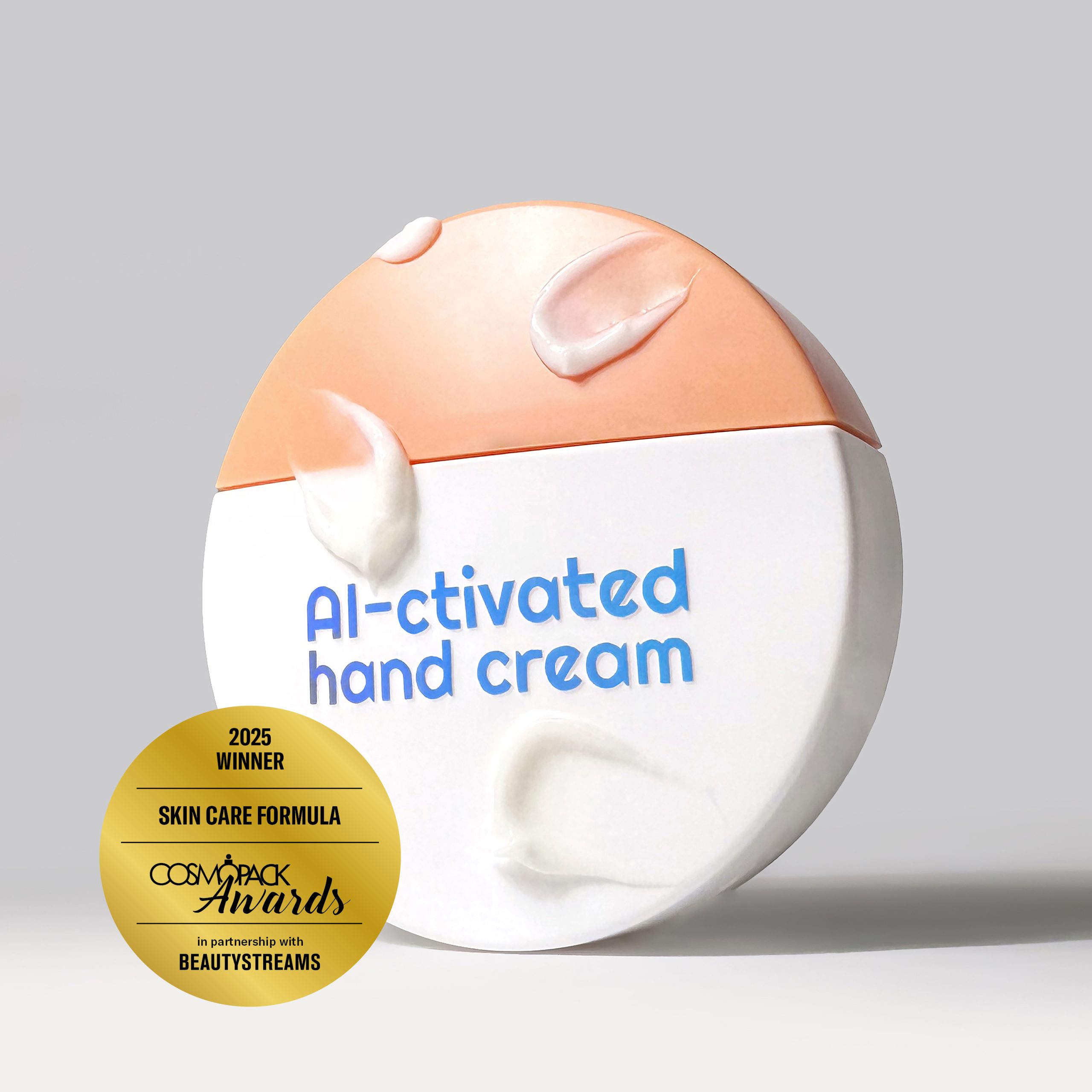 Un’esposizione di prodotti skincare premium con la Blue Light AI ctive Hand Cream di Passage Cosmetics Laboratory, vincitrice del Cosmopack Awards 2025  Il packaging elegante è affiancato dal logo del premio, evidenziando la formula innovativa con enzimi attivati dalla luce blu per la riparazione del DNA e una fragranza unica creata dall'intelligenza artificiale 
